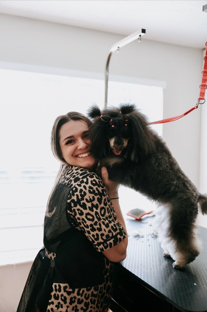 Alissa, nationally certified groomer, with two happy dogs